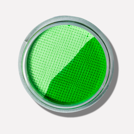 Green makeup compact on a light gray background