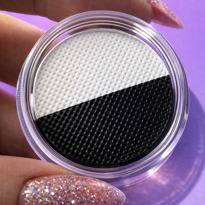 Close-up of a black and white textured filter in a clear container against a purple background.