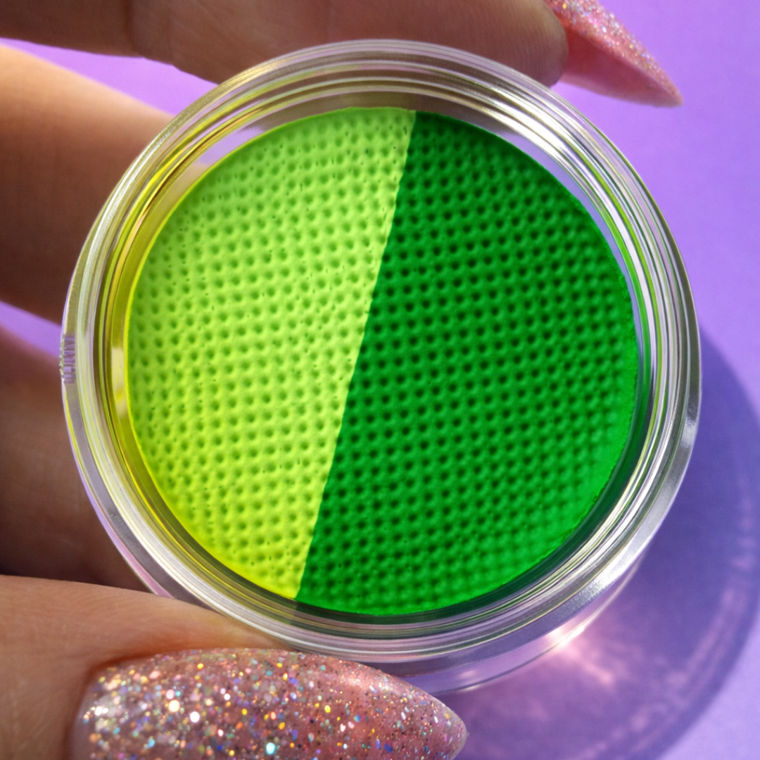 Close-up of a container with green and yellow textured filters held by a hand on a purple background.