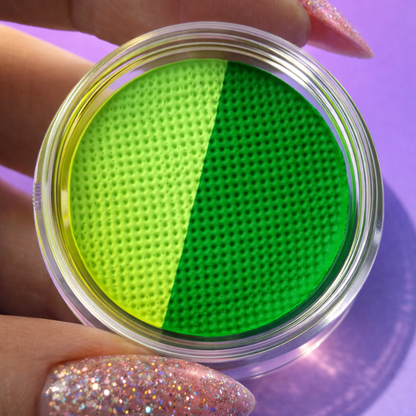 Close-up of a container with green and yellow textured filters held by a hand on a purple background.