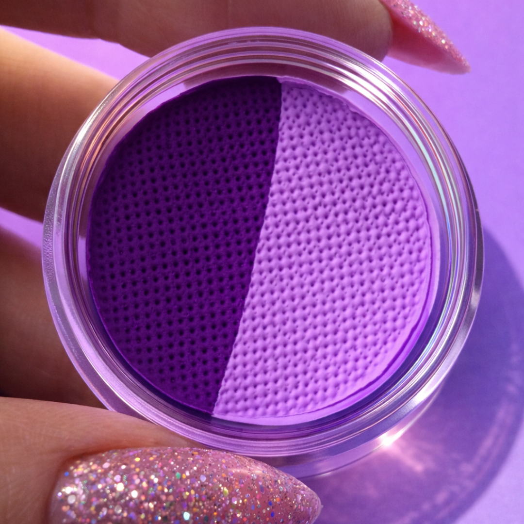 Purple contact lens case held by a hand with glittery nails on a purple background