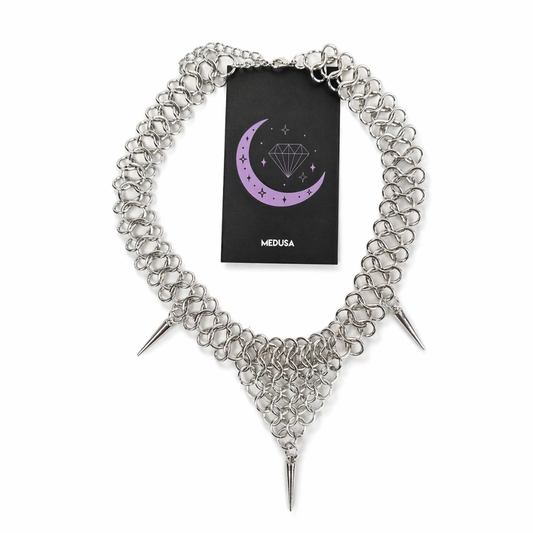 Silver chain necklace with spikes and Medusa branded card on a white background