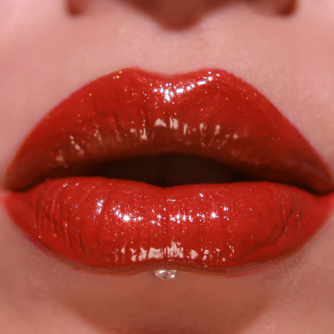 Close-up of glossy red lipstick on lips