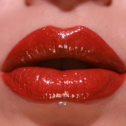 Close-up of glossy red lipstick on lips