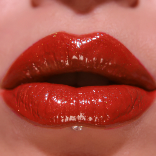 Close-up of glossy red lipstick on lips