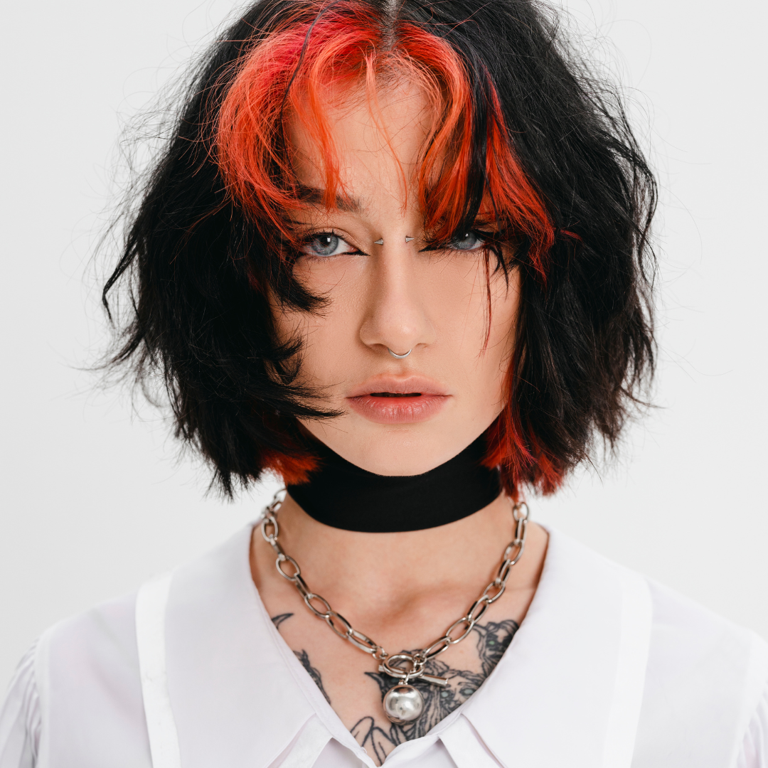 Person with black and red hair wearing a white shirt and black choker.