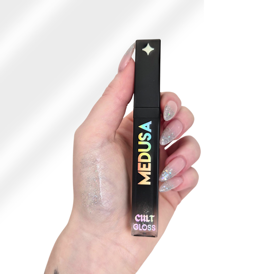 Hand holding a Cilt Medusa gloss with a white background