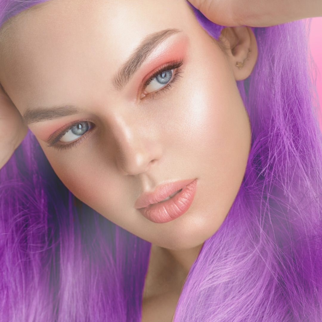 model with purple hair and wearing halo glow highlighter face stick