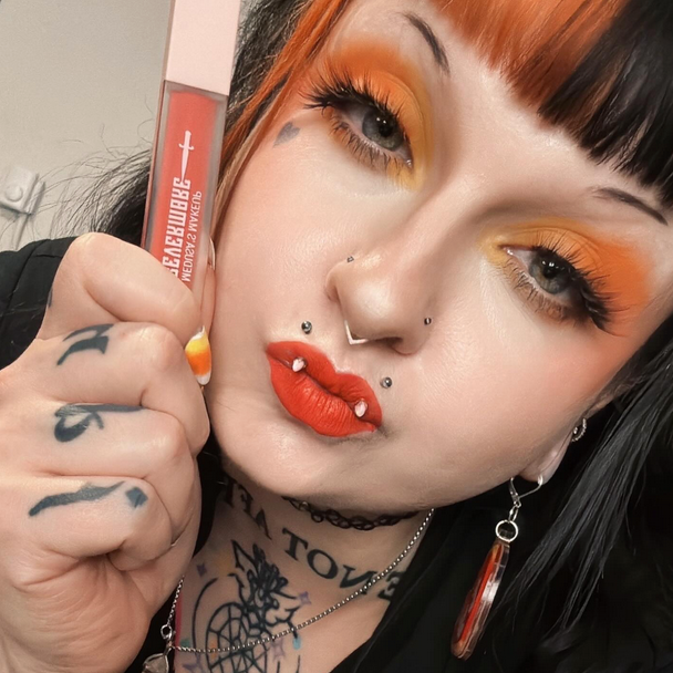 Person with bold makeup holding a makeup product