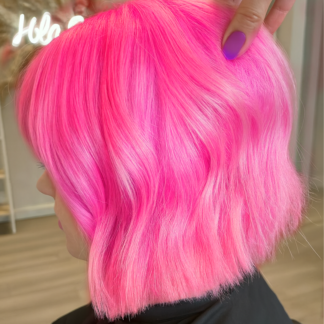 Close-up of bright pink hair with a blurred background