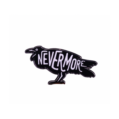 An enamel pin shaped like a raven with the words 'NEVERMORE' written across its body.