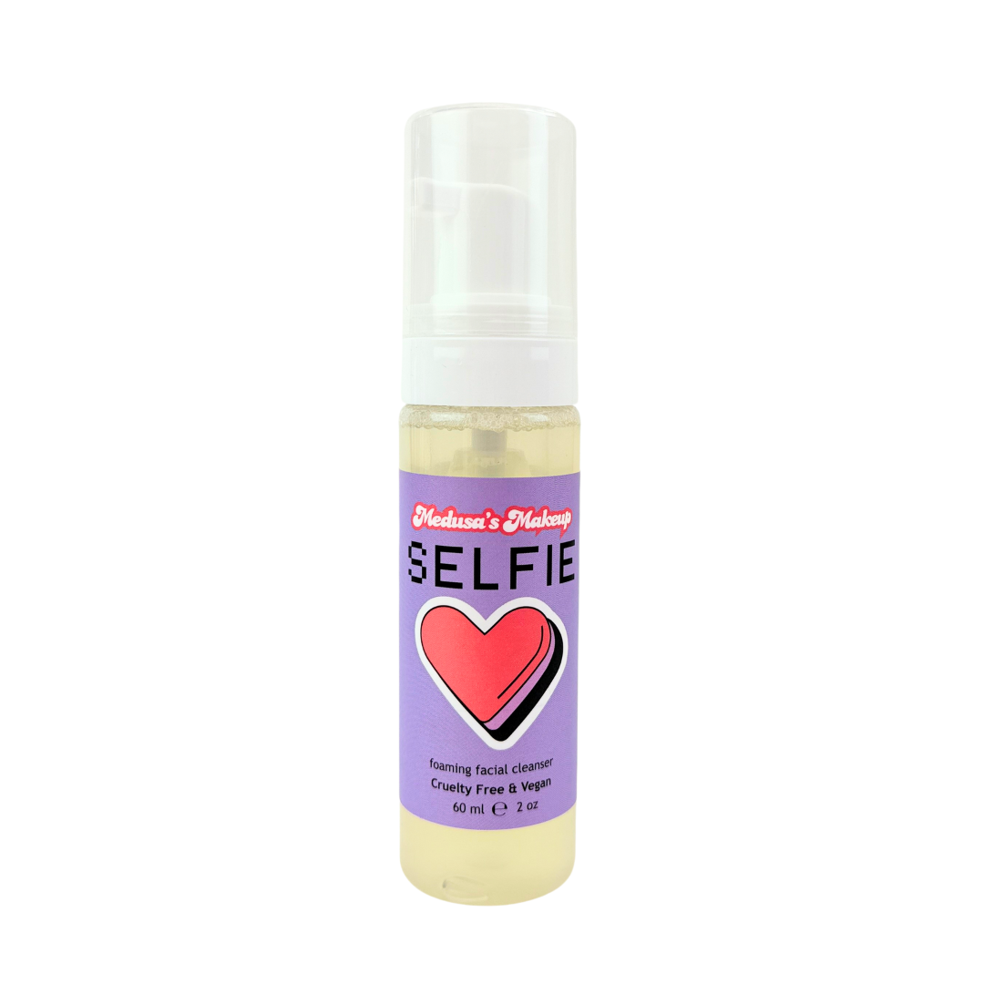 Bottle of 'Selfie' product with a purple label featuring a red heart on a white background