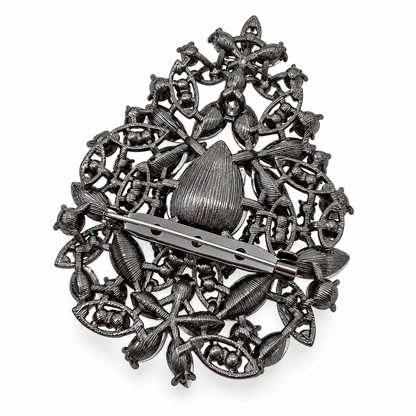 A vintage silver filigree brooch featuring a central teardrop motif, intricate floral and leaf patterns, and a barrette pin clasp, shown on a plain white background.