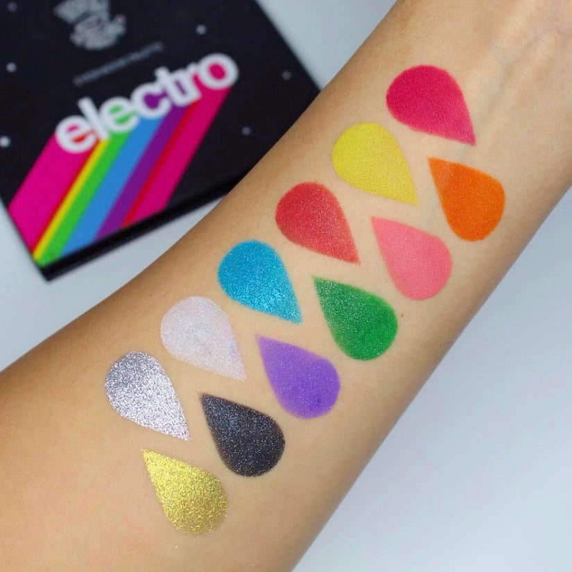 Swatches on arm of The Electro Eyeshadow Palette. Bright eyeshadow colors in a black eyeshadow palette. 12 rainbow colors