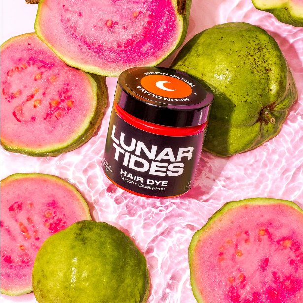 Lunar Tides Hair Dye - Neon Guava in a scenery of opened guava fruit